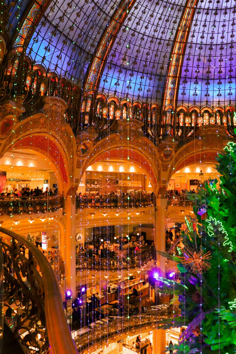 Giant Christmas tree and Santa Claus decoration inside Galeries Lafayette Paris during the holidays.