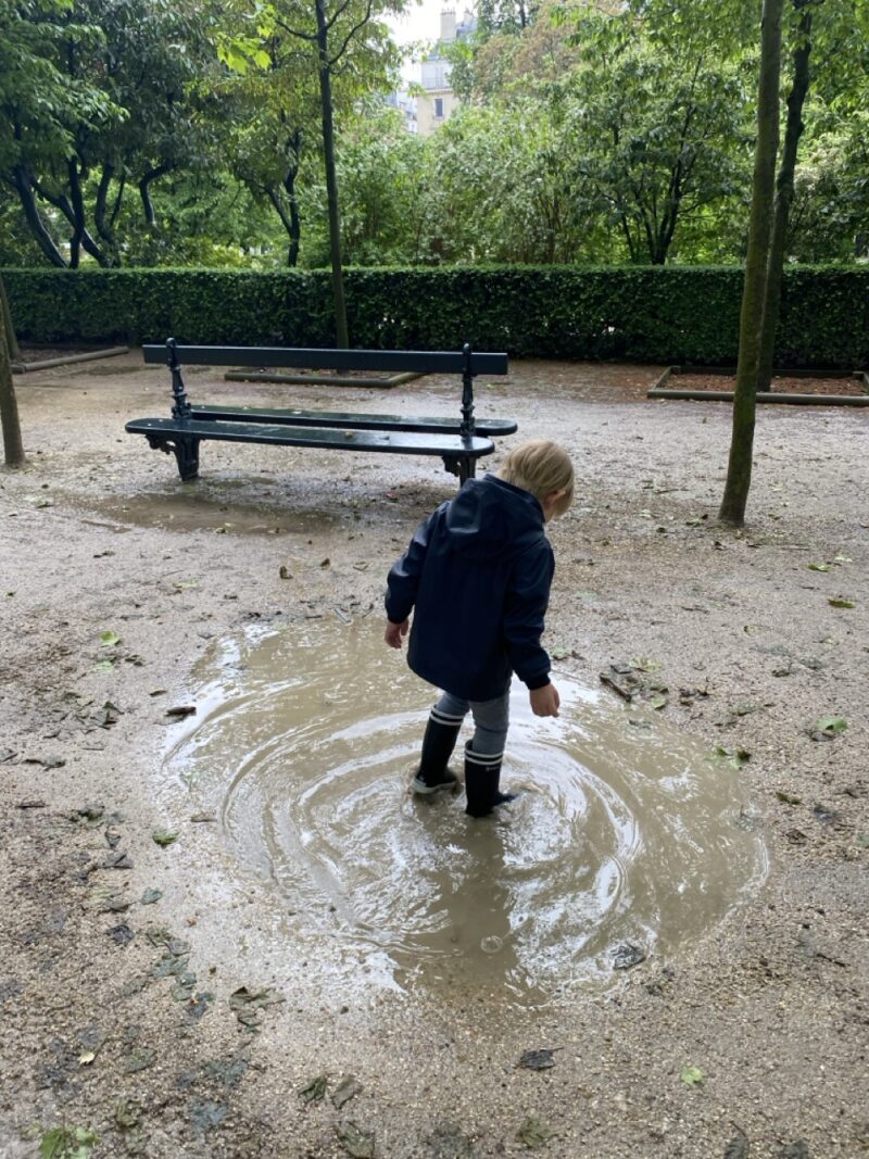 toddler splashing in puddles in a Jardin du Luxembourg Paris park