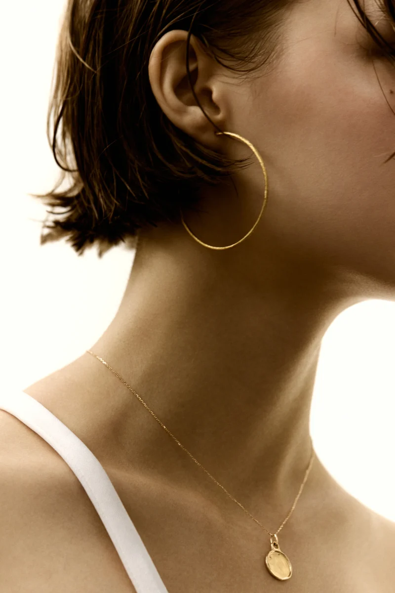 Model wearing gold jewelry