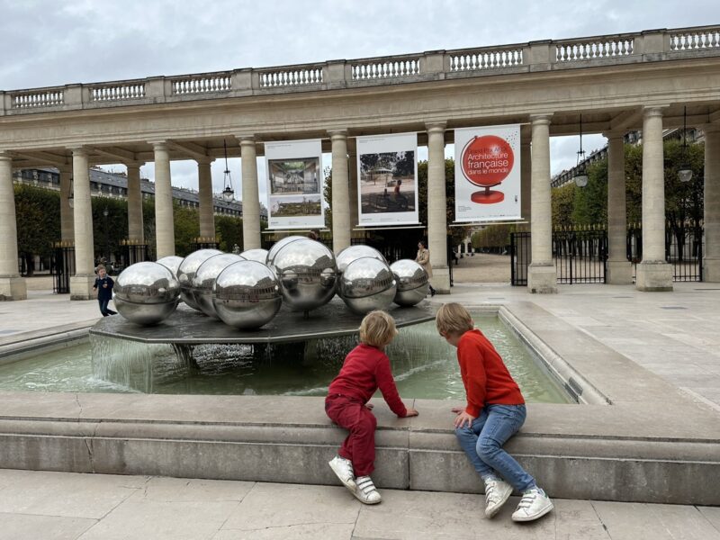 two children playing near the fountain at Palais-Royal Paris in winter