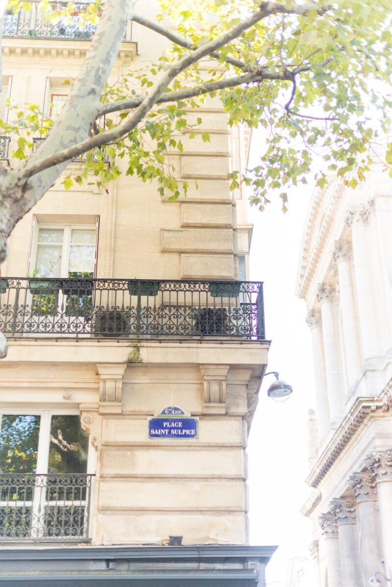 Parisian balcony with iron railing and greenery. A sunlit café terrace captures the relaxed, elegant rhythm of Saint-Germain mornings — the perfect mood for discovering Paris’s most atmospheric neighborhood.