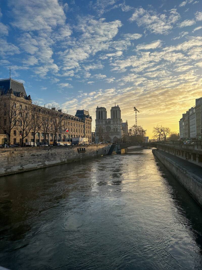 View of the Seine River and Notre-Dame under a winter sunrise in Paris in December.