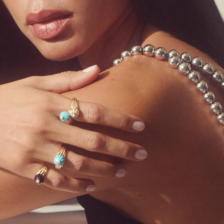 Woman wearing handcrafted gold rings by Salomé Rico, Paris designer.